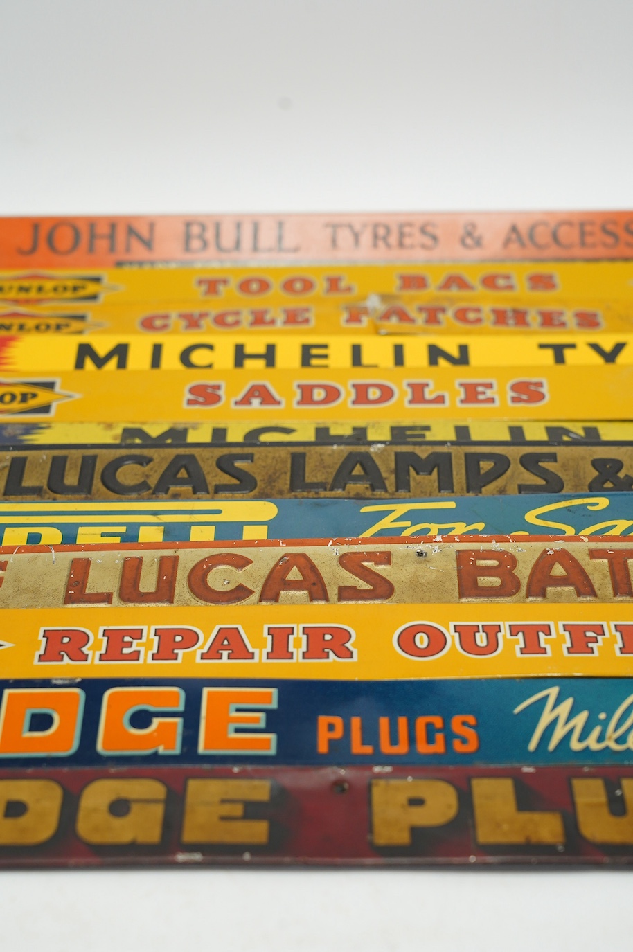 Motoring interest: twelve mid century tinplate advertising shelf strips, largest 48cm, together with a Michelin printed card advertising sign. Condition - poor, fair and good